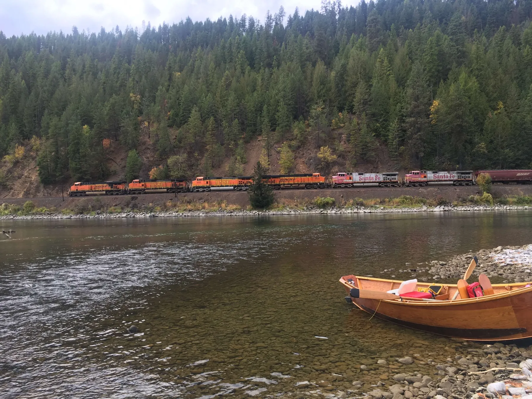 Long Drift Outfitters Fly Fishing Kootenai River boat in the river next to a train