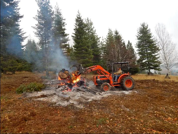 Piling slash in a burn pile