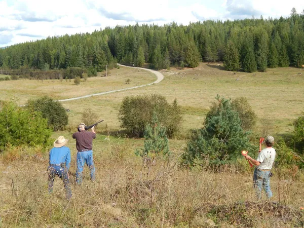 Guests shooting clay pigeons in an open field