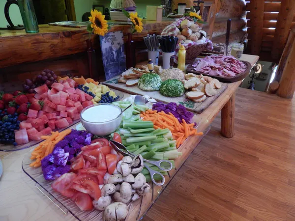 A buffet of fruit, vegetables and meats on a long table in the lodge