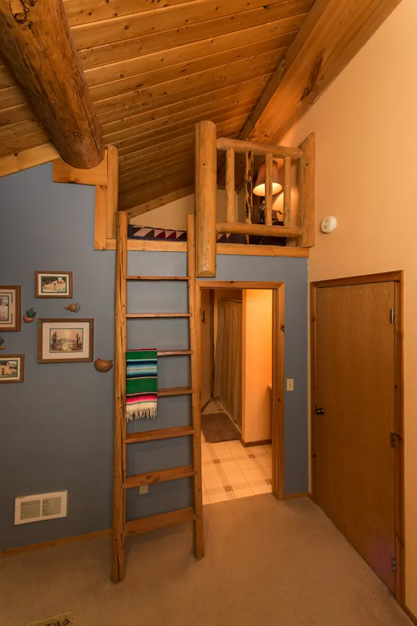 ranch lodge room with ladder into small loft and door into bathroom