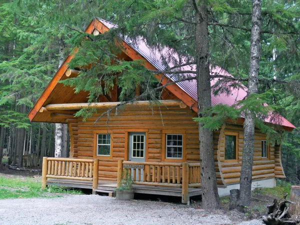 Wrangler log cabin with a red roof and covered porch