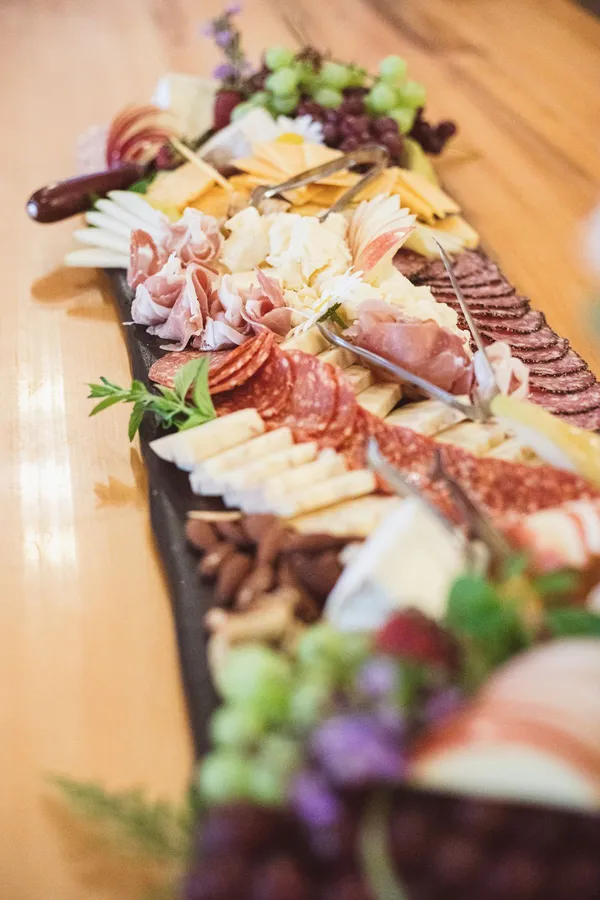 Close-up of a charcuterie board with salami, prosciutto, cheeses, almonds, grapes and apple slices