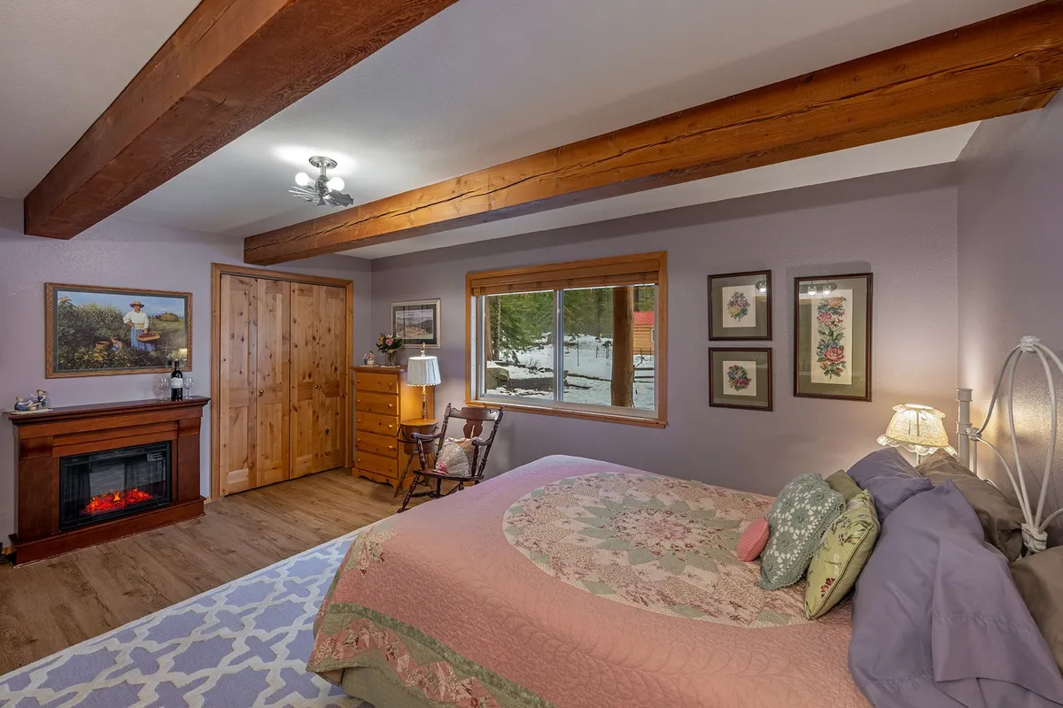 Grandma's Room, looking across the quilted bed to an electric fireplace, a rocking chair and a window onto the snow