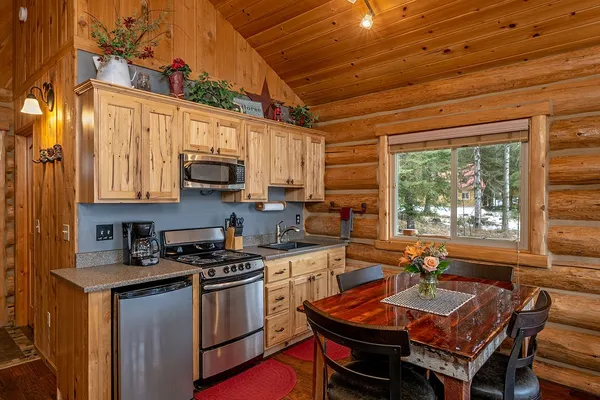 Meadow View Cabin kitchen, with a gas range, a small refrigerator and a high dining table