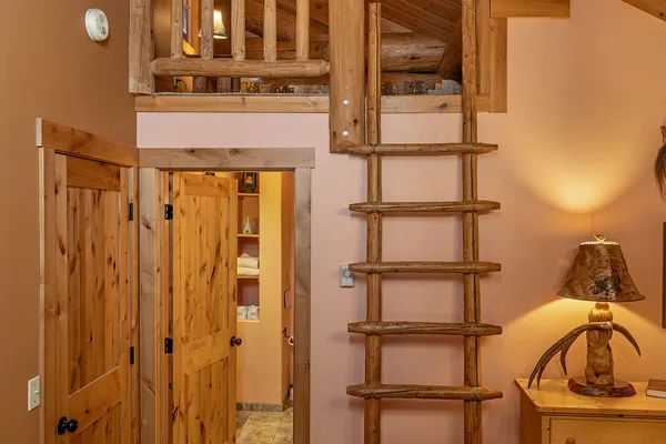 Log ladder up to the hideaway loft in the Nez Perce room, beside the bathroom door