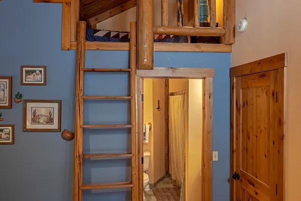 Log ladder up to the loft in the Siesta room, with the bathroom door below