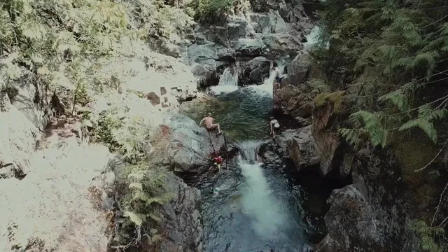 Looking down on Grouse Creek Falls tumbling through mossy rock into a pool