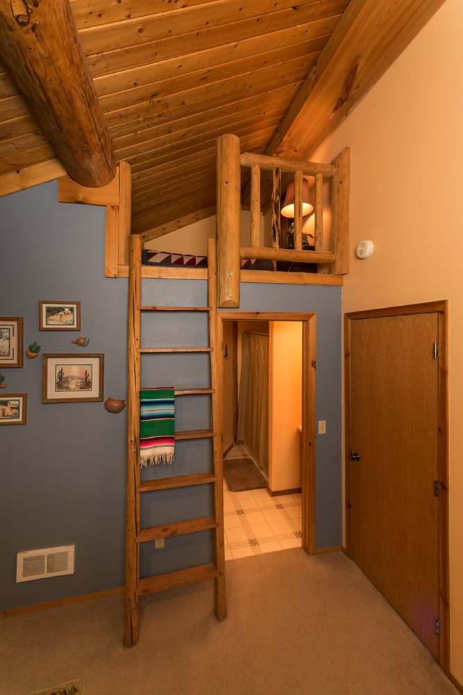 ranch lodge room with ladder into small loft and door into bathroom