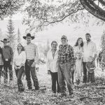 Western Pleasure Guest Ranch Family Photo in black and white family stands together under a tree